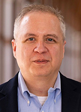 Man wearing a dark blazer and light blue shirt