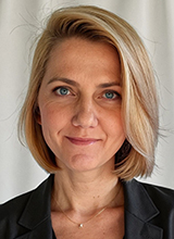Photo of woman with short blonde hair, wearing a black blazer
