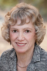 Blonde-haired woman wearing a patterned gray blazer